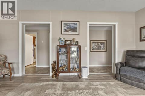 Hallways to bedrooms (primary to right, 2 other bedrooms and main bath to left) at 12560 Westside Road Unit# 77, Swan Lake West, Vernon