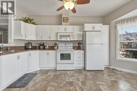 Newly refinished cabinets and paint brighten and modernize the open kitchen at 12560 Westside Road Unit# 77, Swan Lake West, Vernon