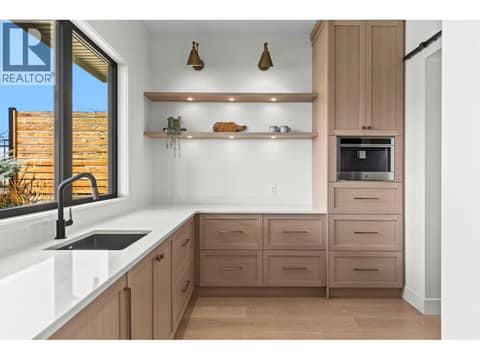 Butler pantry with second sink, coffee area and florting shelves with accent lighting at 74 Red Sky Court, Wilden, Kelowna