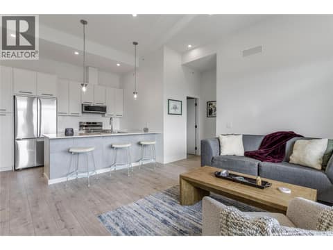 Enjoy the open-concept living room and kitchen with loads of natural light at 1220 Pacific Avenue Unit# 507, Springfield/Spall, Kelowna