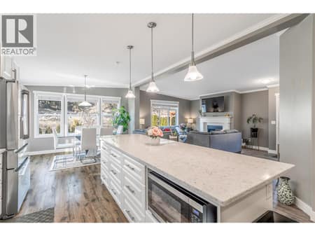 Bright and modern kitchen featuring stone countertops and stainless steel appliances at 1835 Nancee Way Court Unit# 48, West Kelowna Estates