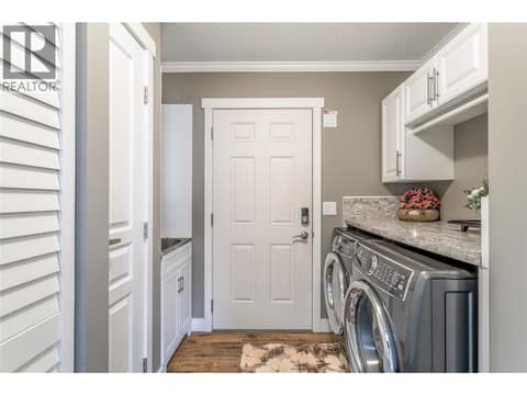 Laundry room with sink, and access to the double attached garage at 1835 Nancee Way Court Unit# 48, West Kelowna Estates