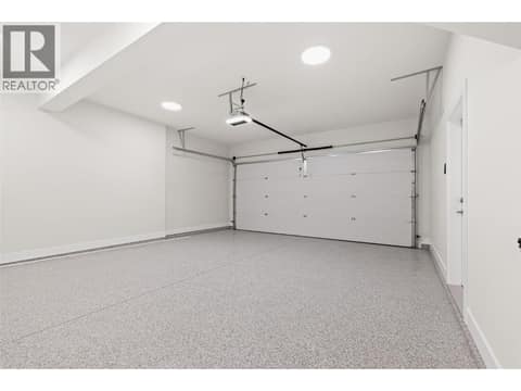 Attached Double-Car Garage | Lower Level - With 10ft ceilings and epoxy floors at 1448 Whistling Pine Place, Wilden, Kelowna