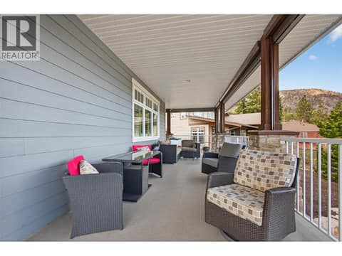 Covered wraparound veranda — the perfect place to enjoy a meal outside or soak up the sun from every angle. at 2478 Stone Grove Crescent, Shannon Lake, West Kelowna