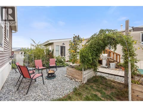 A thoughtfully landscaped yard with raised garden beds, mature plantings and inviting spaces to gather around the fire. at 9020 Jim Bailey Road Unit# 174, Lake Country East / Oyama, Kelowna