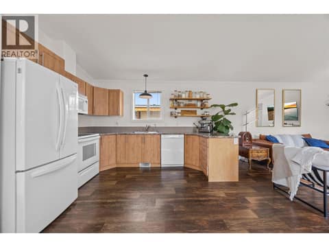 Warm wood cabinetry complements the rich flooring throughout. at 9020 Jim Bailey Road Unit# 174, Lake Country East / Oyama, Kelowna