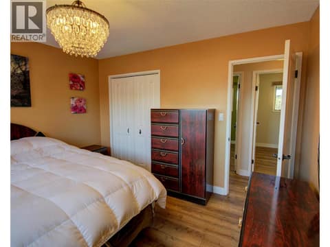 Primary bedroom with cheater door to bathroom at 5894 Dedecker West Road, North BX, Vernon