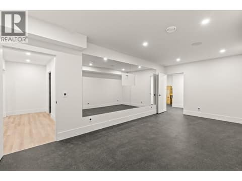 Gym with rubber floors and mirrored wall at 5584 Upper Mission Court, Kettle Valley, Kelowna