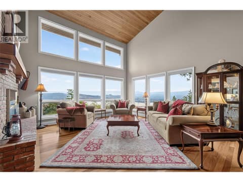Vaulted ceiling living sapce anchored by a floor to ceiling fireplace at 1776 Keloka Drive, West Kelowna Estates