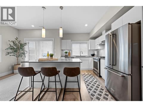 Contemporary kitchen with quartz countertops, KitchenAid appliances and a large island with seating. at 255 Taylor Road Unit# 18, Rutland South, Kelowna