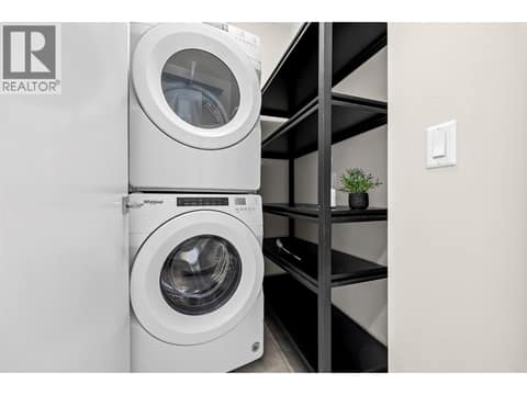 Convenient upper-level laundry with stacked washer and dryer plus additional shelving and storage. at 255 Taylor Road Unit# 18, Rutland South, Kelowna