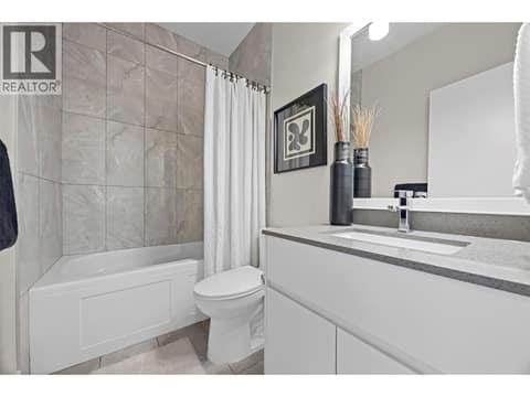 Full upper-level bathroom with quartz countertop and tiled tub/shower surround. at 255 Taylor Road Unit# 18, Rutland South, Kelowna