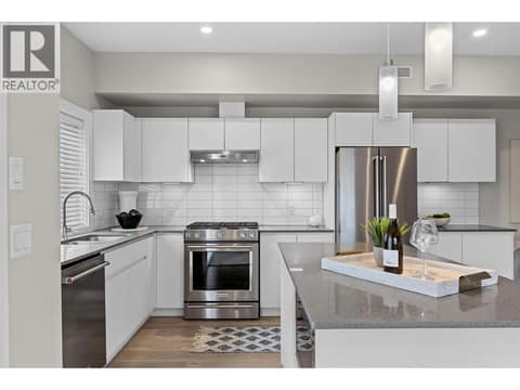 Sleek cabinetry, quartz countertops, tile backsplash and stainless steel appliances. at 255 Taylor Road Unit# 18, Rutland South, Kelowna