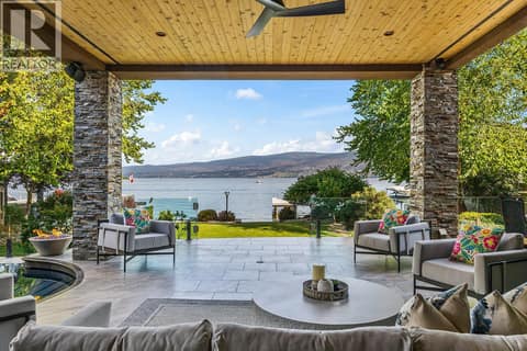 Your lakefront view from the main floor, perfectly framed by mature trees and stone-clad columns at 4165 Gellatly Road, Westbank Centre, West Kelowna