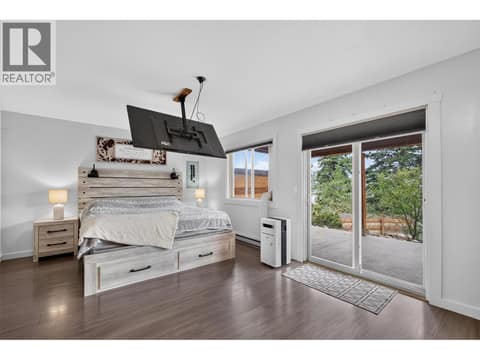 Primary bedroom with sliding glass doors at 10375 Westshore Road, Okanagan North, Vernon