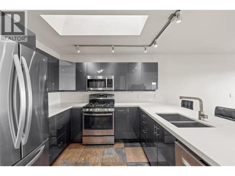 Kitchen | Main Level - Updated kitchen with quartz countertops, cabinetry, stainless steel appliances & flooring at 1525 Bear Creek Road Unit# 14, West Kelowna Estates