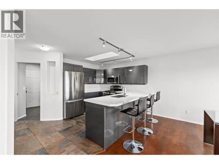 Kitchen | Main Level - Updated kitchen with quartz countertops, cabinetry, stainless steel appliances & flooring at 1525 Bear Creek Road Unit# 14, West Kelowna Estates