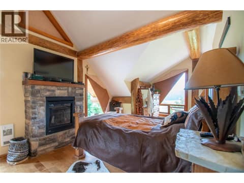 Master Bedroom with gas fireplace, angular vaulted ceilings, walk-in closet and full ensuite bathroom at 1225 Round Lake Road, Armstrong/ Spall.