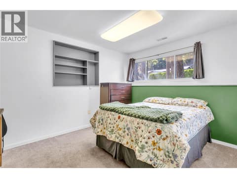 Fourth bedroom (lower level) with built-in shelving at 3227 McIver Road, Glenrosa, West Kelowna