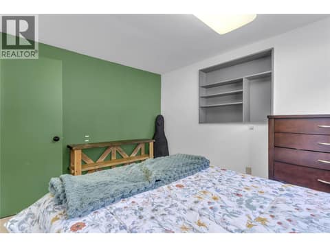 Fourth bedroom (lower level) with built-in shelving at 3227 McIver Road, Glenrosa, West Kelowna