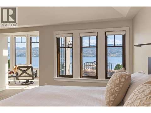 Huge picture windows welcome morning sun in primary bedroom at 3673 Green Bay Landing, Lakeview Heights, West Kelowna