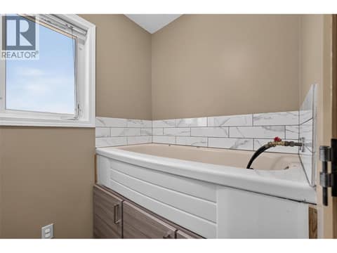 Main-floor laundry also features a dedicated dog wash station at 3040 Seclusion Bay Road, Westbank Centre, West Kelowna