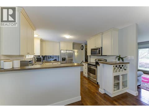 White kitchen with stainless steel appliances at 1859-1861 Mountain Avenue, Glenmore, Kelowna