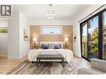 Primary bedroom features a Juliette balcony that overlooks the backyard area at 2053 Long Street, Kelowna South