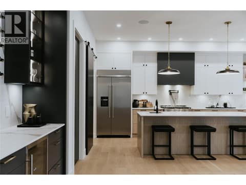 A seamlessly integrated built-in fridge enhances the kitchen's sleek, high end design. at 5533 Foothill Court, Kettle Valley, Kelowna