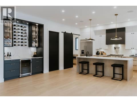 Gorgeous Kitchen & Stylish Bar on main featuring Dekton countertops and backsplash offering unmatched durability and a striking aesthetic. at 5533 Foothill Court, Kettle Valley, Kelowna