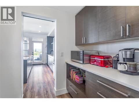 View from the butler pantry to the kitchen area with deck access at 1528 FAWN RUN Drive, Upper Mission, Kelowna