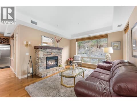 Built-in electric fireplace creates a cozy living space with picture window view. AI enhanced flames. at 2780 Auburn Road Unit# 203, Shannon Lake, West Kelowna