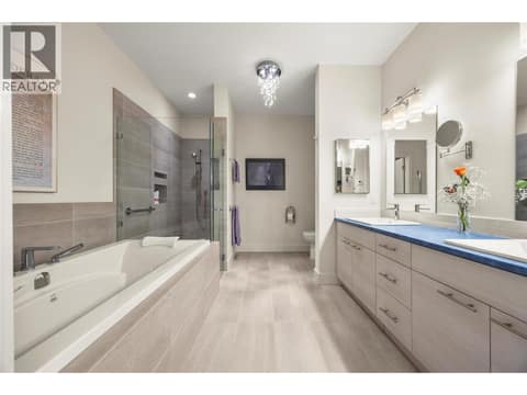 5 PC bathroom Beautifully appointed with dual sinks, a soaker tub with tile surround, curbless walk-in shower with custom tile work & heated tile flooring at 2442 Bella Vista Street, Black Mountain, Kelowna