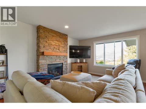 Cozy living room with gas fireplace and expansive views at 110 Red Rock Crescent, Enderby / Grindrod