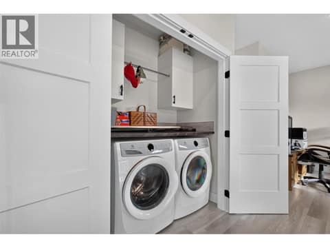 Convenient upstairs laundry located on the same floor as all three bedrooms, with built-in storage and hanging space at 2400 Hawks Boulevard, Westbank Centre, West Kelowna