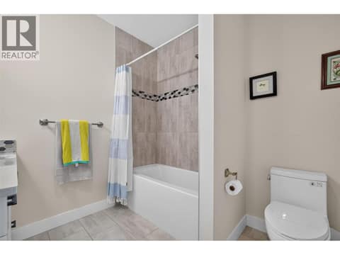 Full upstairs bathroom with a tiled tub/shower surround at 2400 Hawks Boulevard, Westbank Centre, West Kelowna