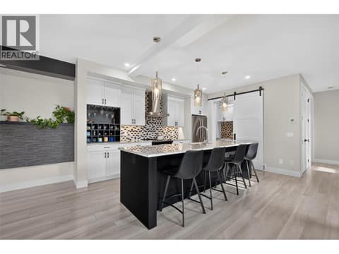 This is the first photo Beautifully appointed kitchen featuring quartz countertops, an oversized island with seating, stylish finishes, and an open-concept layout perfect for entertaining. at 2400 Hawks Boulevard, Westbank Centre, West Kelowna