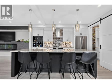 Thoughtfully designed kitchen with an oversized island, plenty of storage and a separate pantry tucked behind the sliding barn door. at 2400 Hawks Boulevard, Westbank Centre, West Kelowna