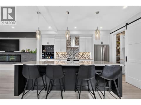 Thoughtfully designed kitchen with an oversized island, plenty of storage and a separate pantry tucked behind the sliding barn door. at 2400 Hawks Boulevard, Westbank Centre, West Kelowna