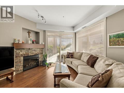 Cozy stone electric fireplace with a mantle. at 3545 Carrington Road Unit# 108, Westbank Centre, West Kelowna