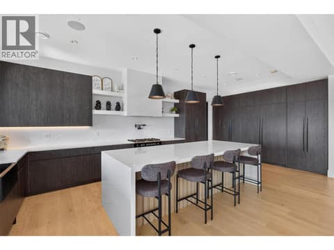Chef inspired kitchen with an oversized waterfall island, custom cabinetry, pot filler and sleek modern finishes. at 1531 Cabernet Way, Lakeview Heights, West Kelowna