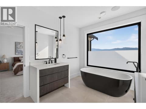 Spa inspired primary ensuite with a freestanding soaker tub and lake views. at 1531 Cabernet Way, Lakeview Heights, West Kelowna