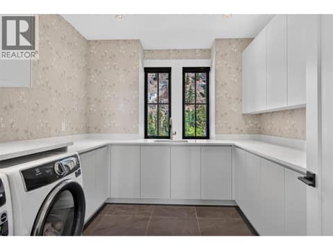 Upstairs laundry room with extensive custom cabinetry, sink and workspace. at 1531 Cabernet Way, Lakeview Heights, West Kelowna