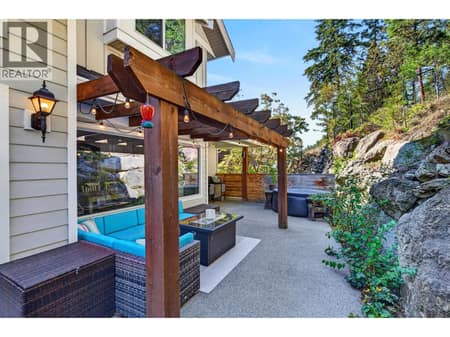 Private outdoor patio with pergola, hot tub and natural rock backdrop. at 178 Terrace Hill Court, Wilden, Kelowna