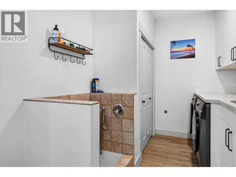 Spacious laundry room with extensive cabinetry, countertop workspace and a built-in pet wash station. at 178 Terrace Hill Court, Wilden, Kelowna