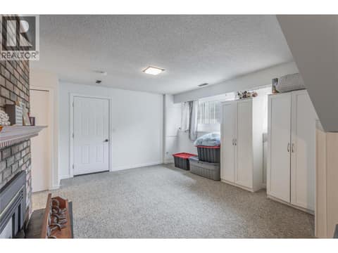 Lower-level family room. The door leads to the garage. at 3341 Webber Road, Glenrosa, West Kelowna