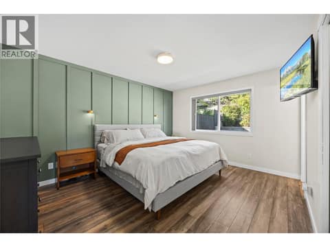 Primary bedroom with ensuite with views of the backyard & surrounding forest at 2322 Shannon Heights Place, Shannon Lake, West Kelowna