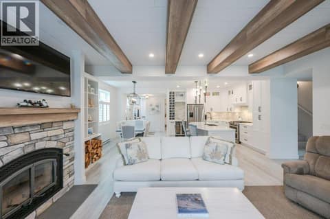 Living room with custom beams & Napoleon wood-burning fireplace at 2450 Radio Tower Road Unit# 58, Oliver Rural