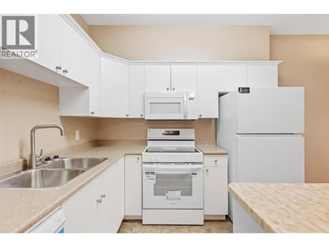 Dual stainless-steel sinks and a butcher-block island at 1125 Bernard Avenue Unit# 302, Kelowna North