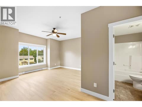 Spacious, king-sized bedroom with an oversized closet featuring mirrored sliding doors, east-facing window at 1125 Bernard Avenue Unit# 302, Kelowna North